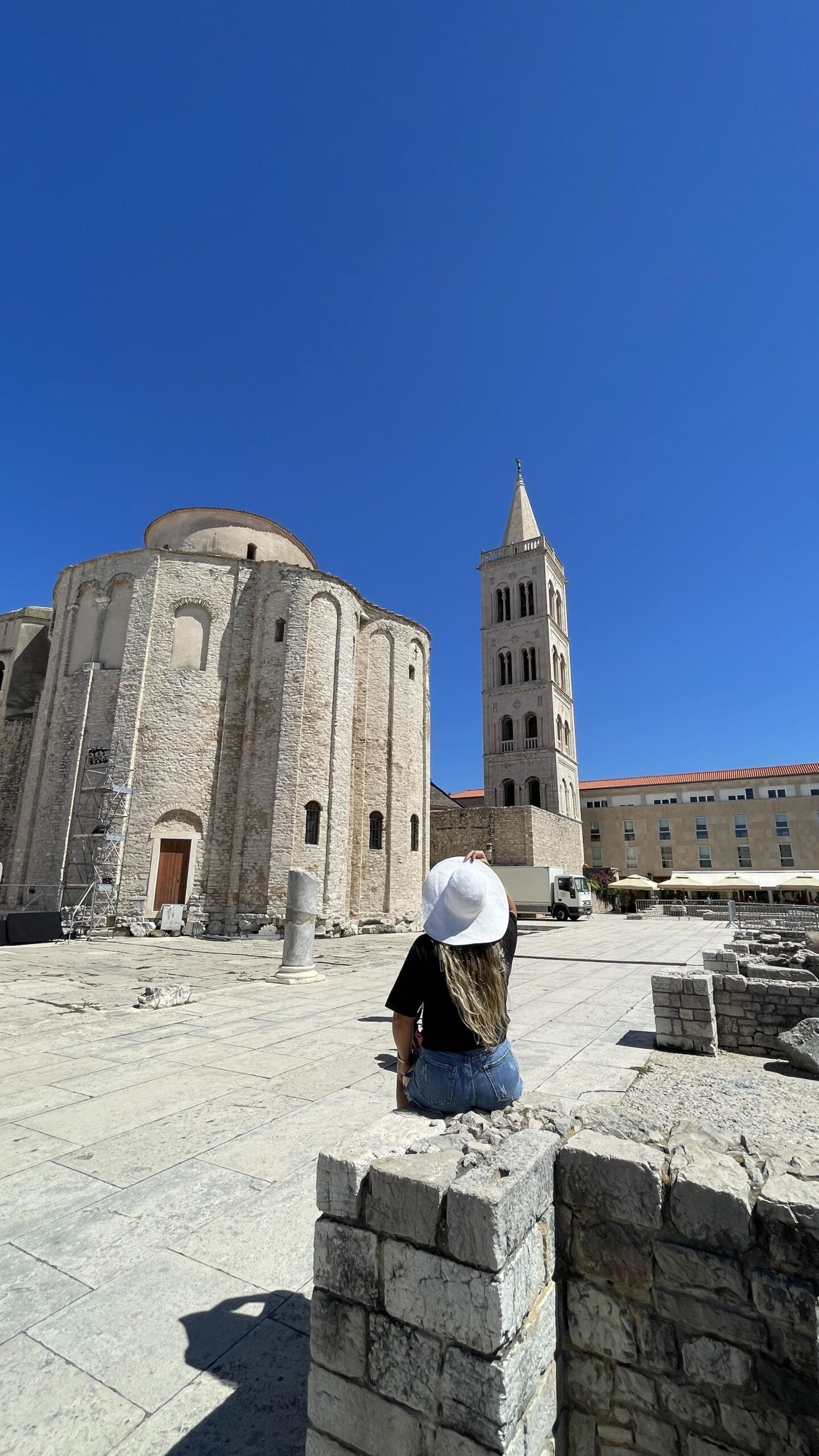 mujer sentada mirando hacia una catedral en Zadar, Croacia