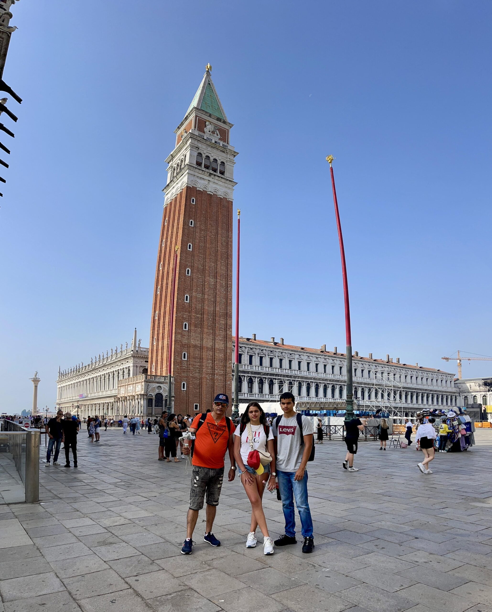 un hombre, un joven y una chica en la plaza de San Marcos en Venecia