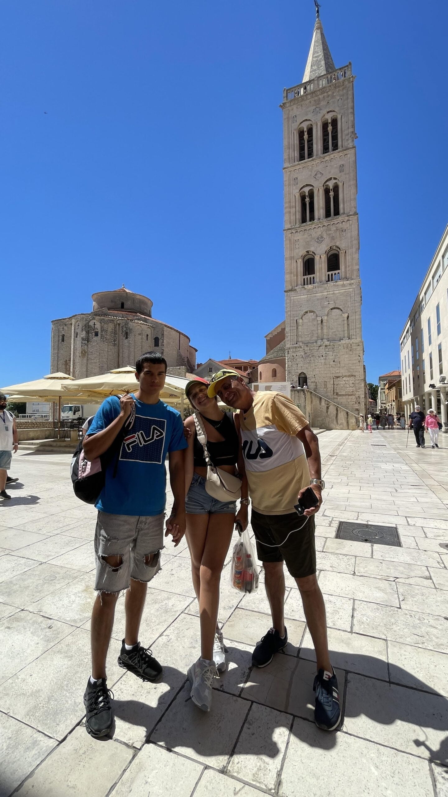 un hombre, un chicop y una chica en el centro histórico de Zadar en Croacia
